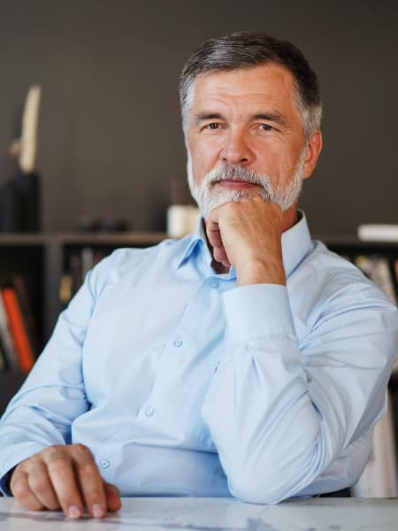 Senior man contemplating at a desk